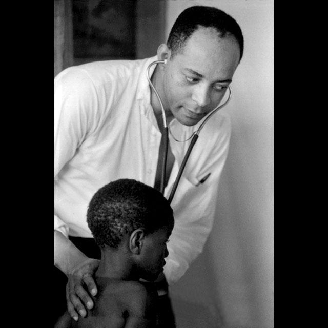 A black and white photograph of a doctor examining a child at a Head Start Center during the Poor People’s Campaign