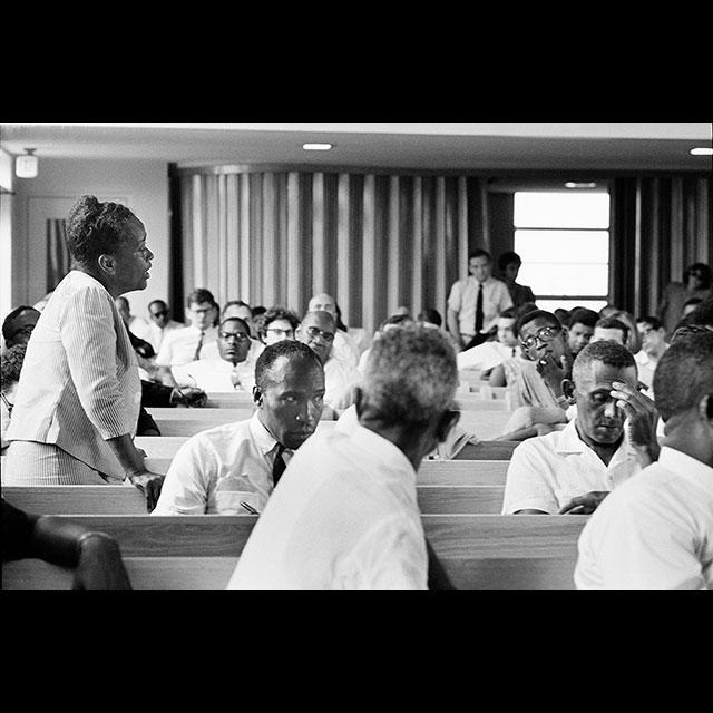 A black and white photograph of Ella Baker delivering a speech to MFDP delegates