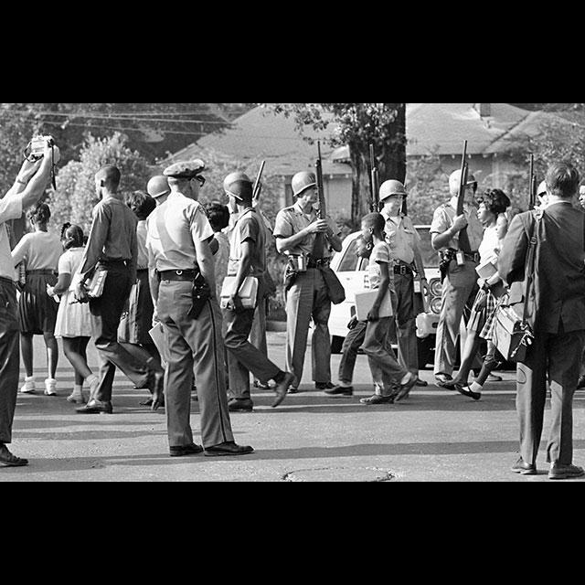 A black and white photograph of Black students walking to school in 1966